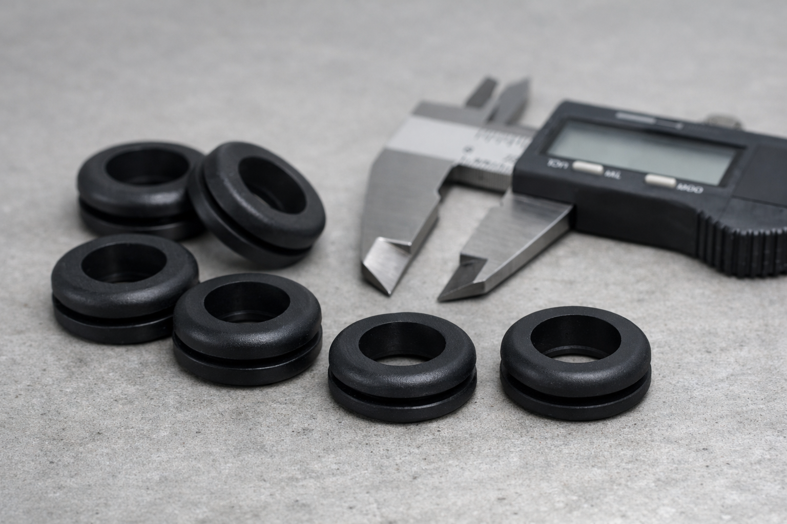 Flexible grommets on a workbench with measuring tool